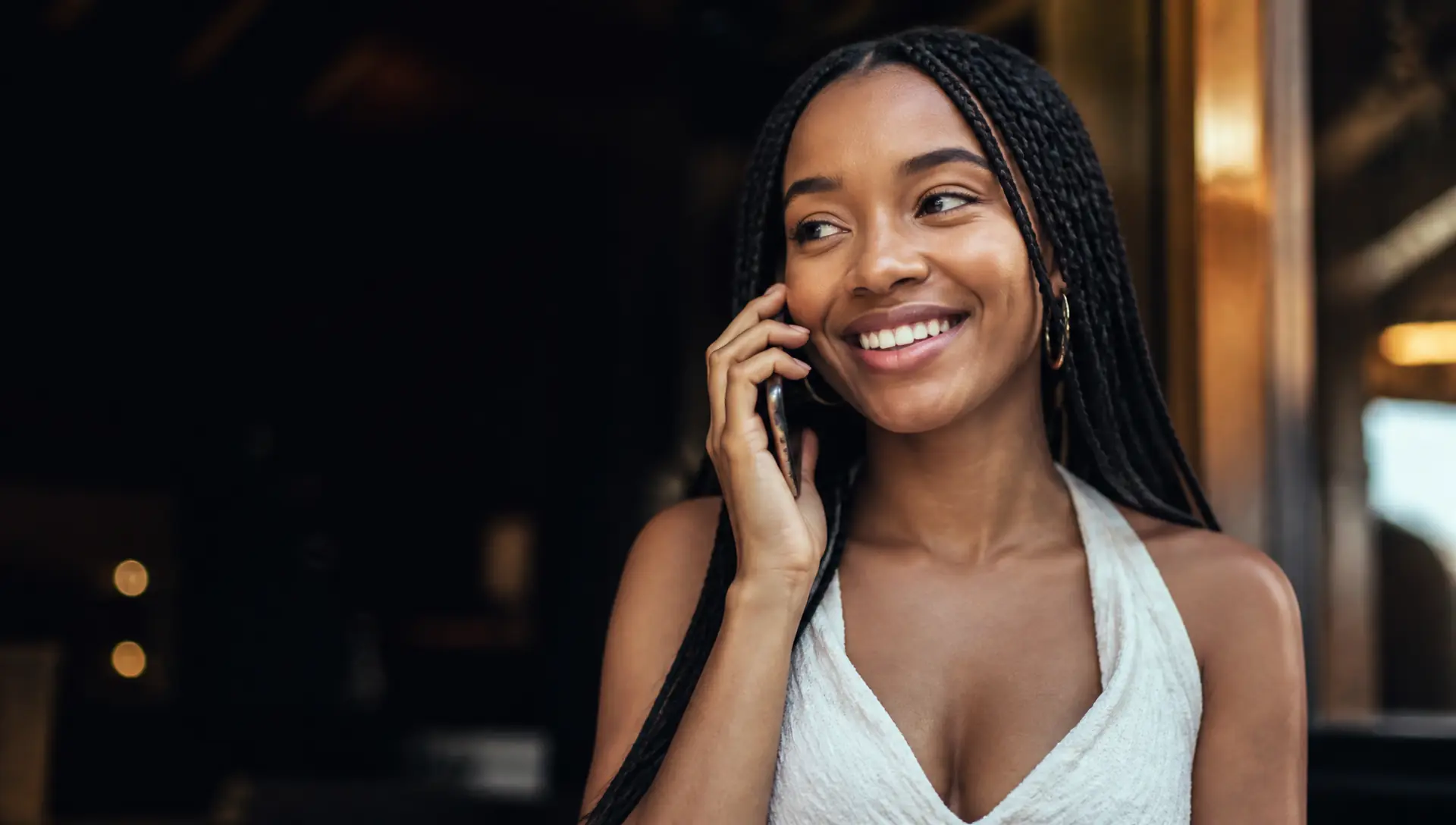 Smiling client with long braids calling to book her appointment